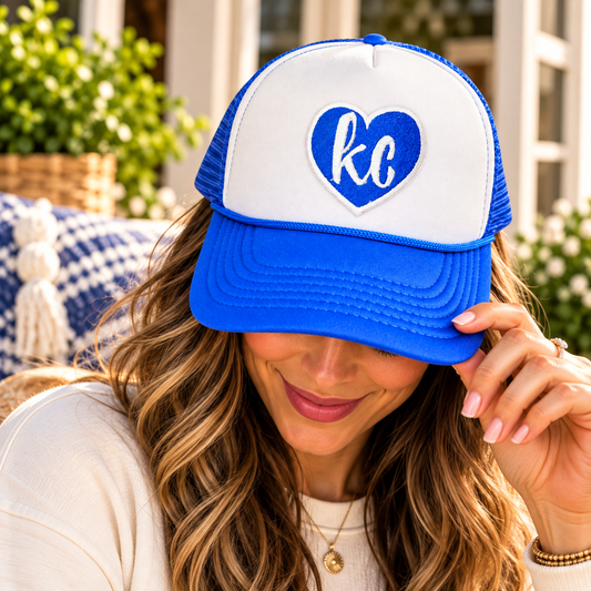 Woman wearing the royal blue and white KC heart embroidered trucker hat