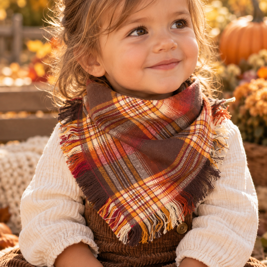 Rustic autumn plaid fringe bib-dana worn by a toddler