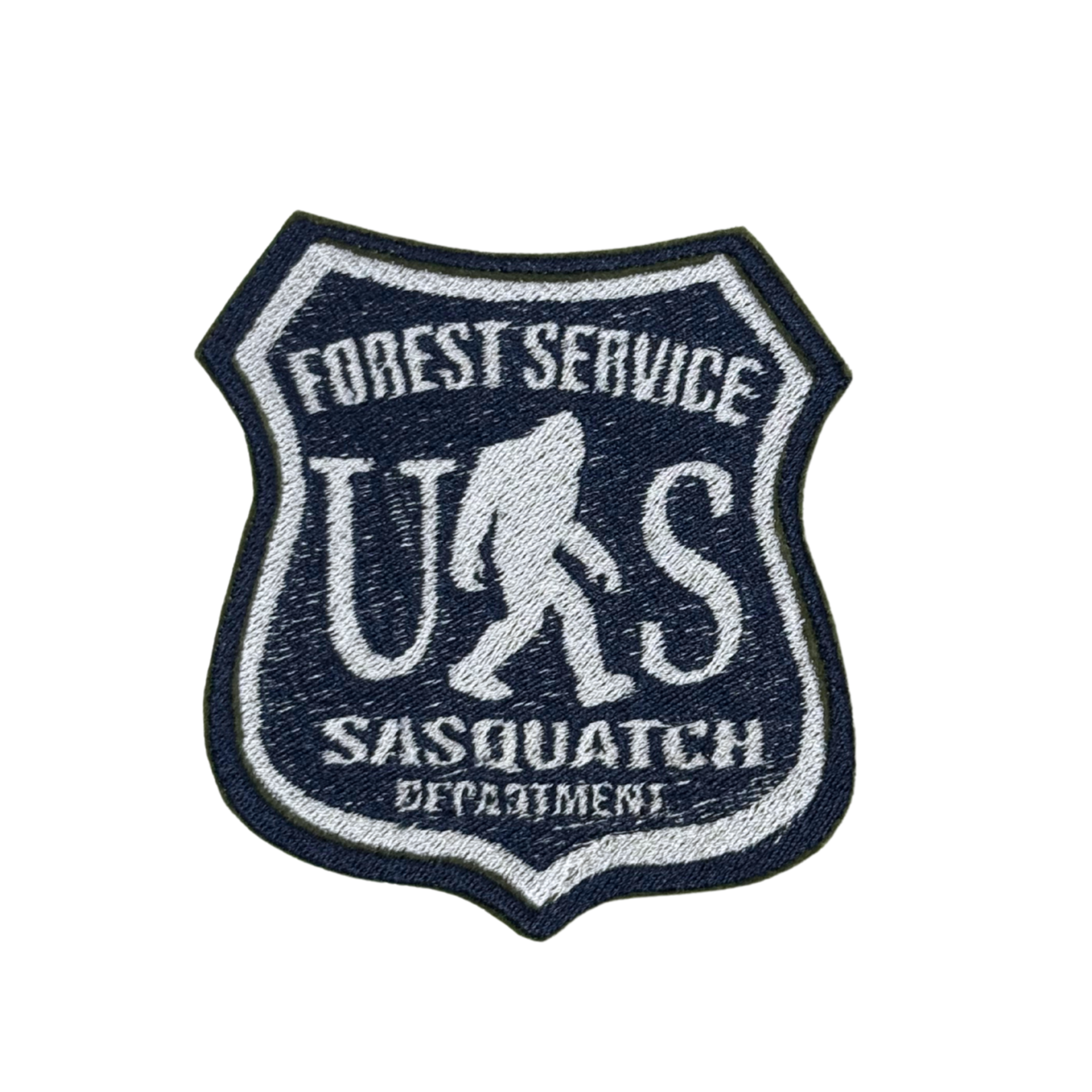 Close-up of an embroidered Sasquatch Forest Service patch in navy and white.

