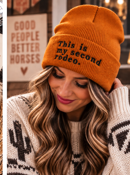 Woman wearing dark orange This Is My Second Rodeo embroidered beanie