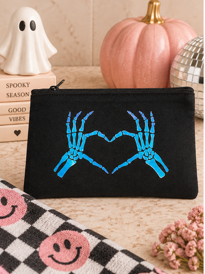 Black Skeleton Heart Hands zip pouch styled with spooky pink Halloween decor