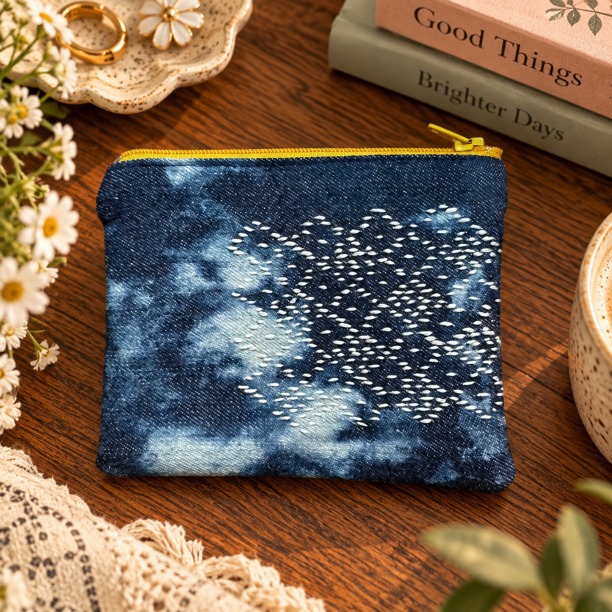 Small hand-stitched sashiko zip pouch with yellow zipper styled product photo