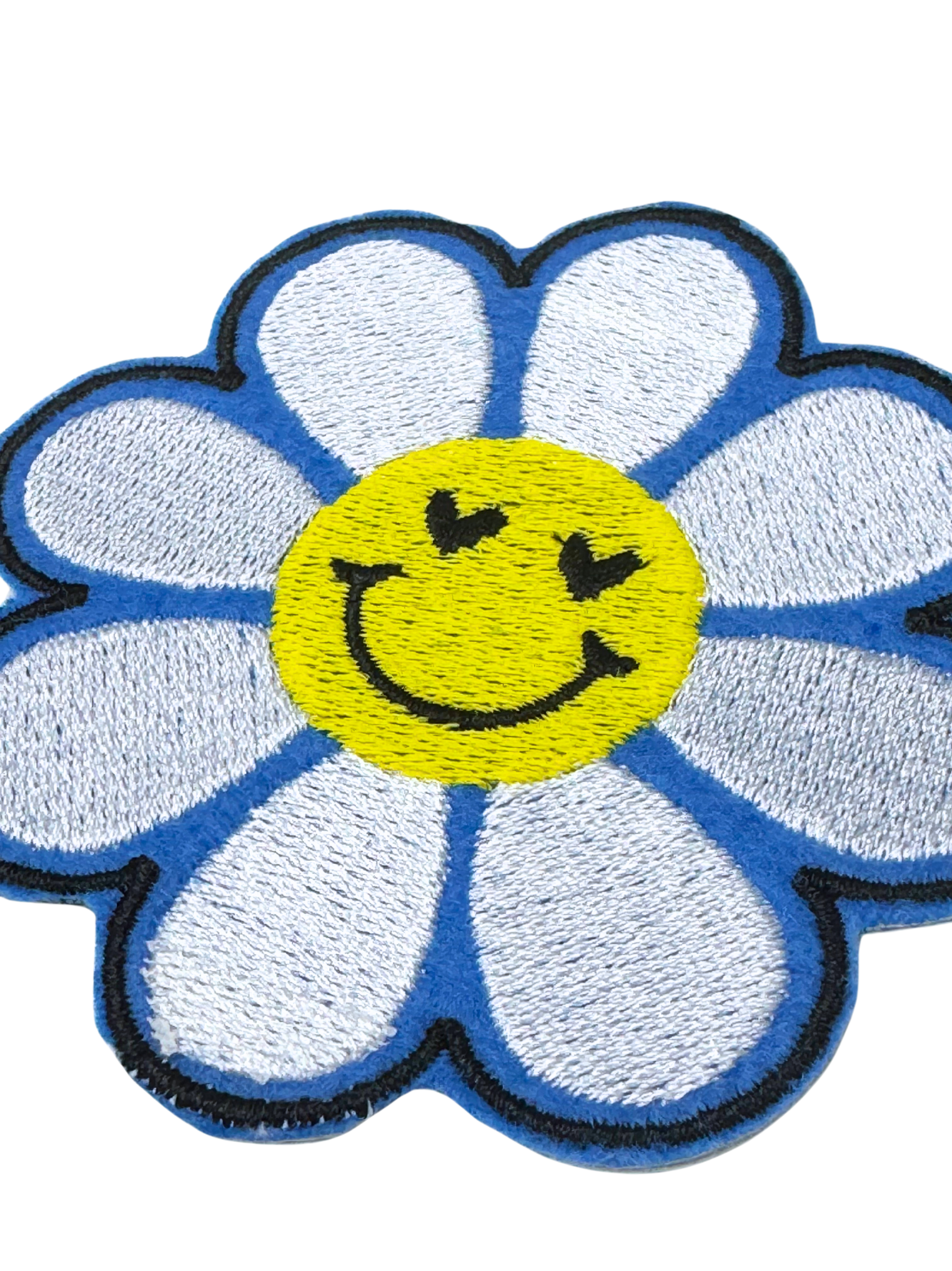 Close-up of blue daisy iron-on patch showing texture and stitching