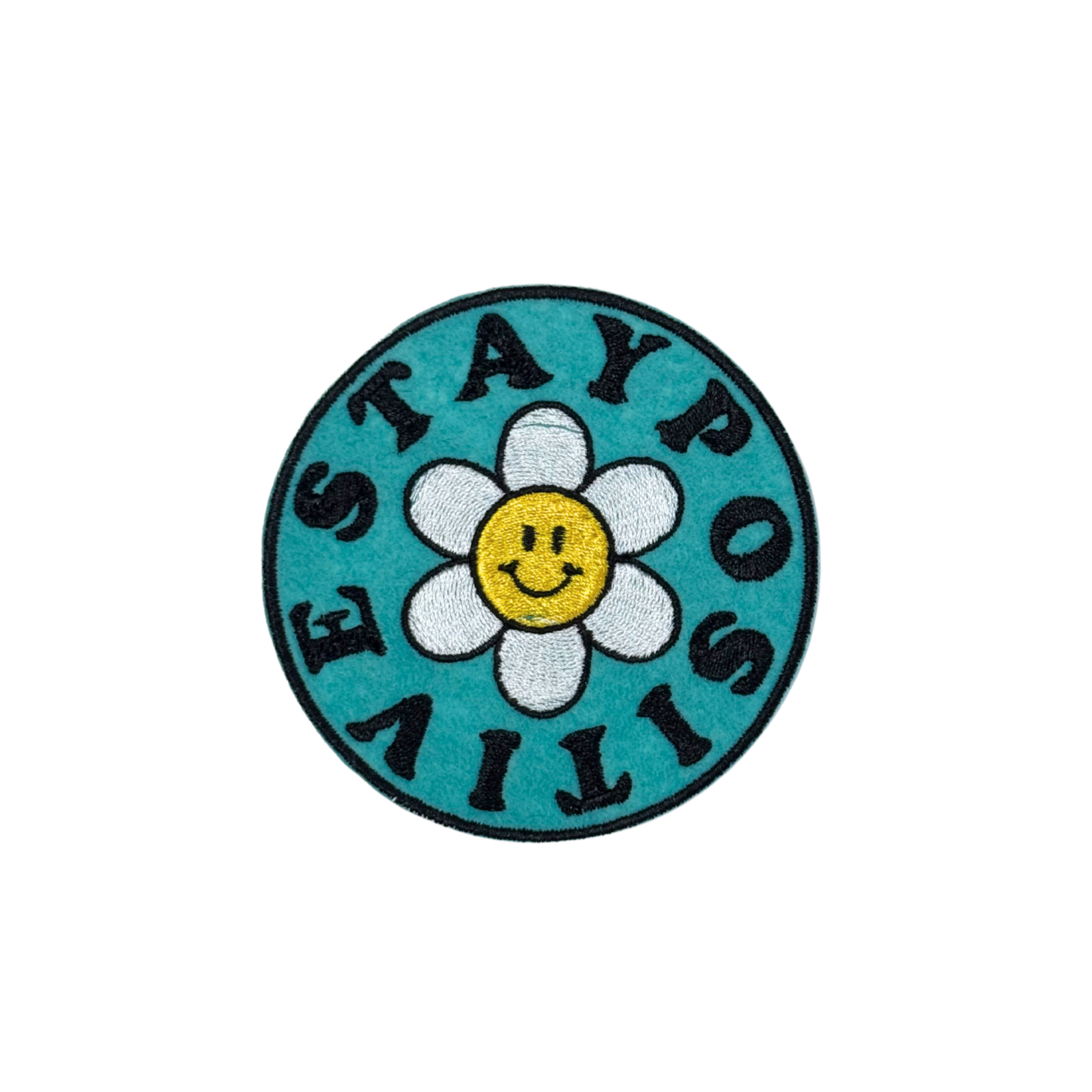 "Round embroidered patch with a turquoise background, a smiling daisy in the center, and the phrase 'Stay Positive' in bold black letters."
