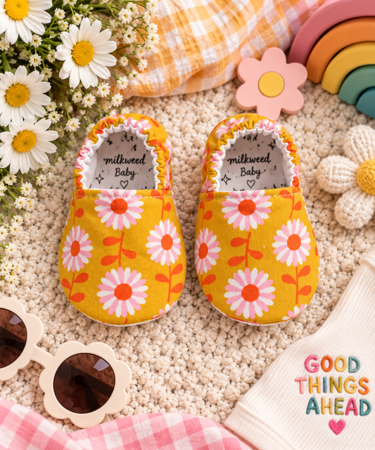 Sunshine Daisy Baby Moccasins styled with daisies, colorful toys and cheerful baby accessories