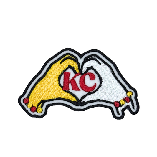 KC patch with red KC letters inside yellow and white hands forming a heart shape