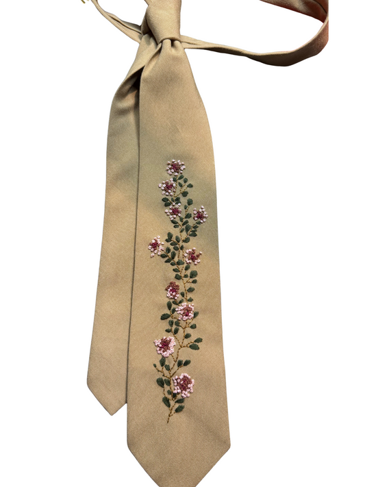 Beige tie with floral embroidery on a white background