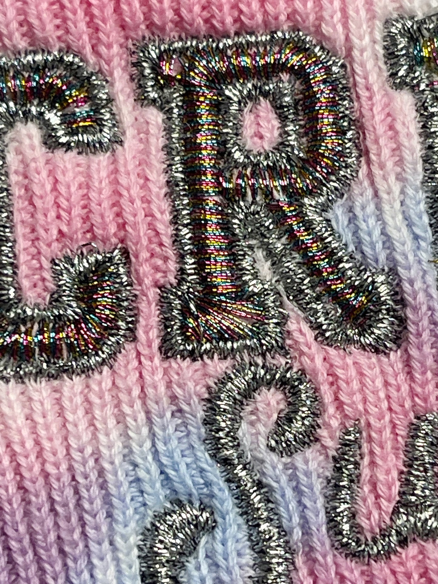 detail view of embroidery and thread colors on Taylor Swift Cruel Summer pink and blue tie dye embroidered knit beanie
