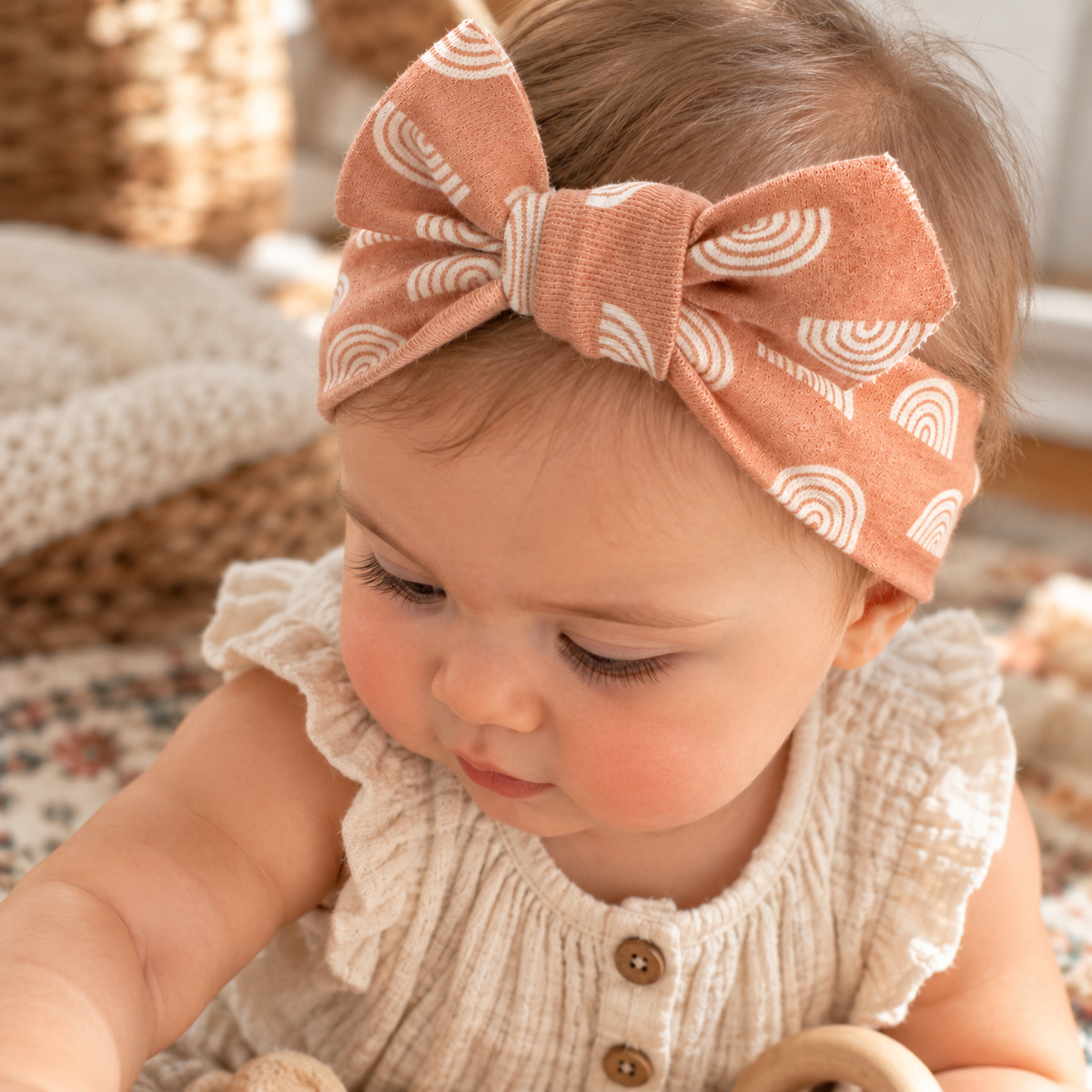 Baby wearing terracotta rainbow organic cotton bow headband