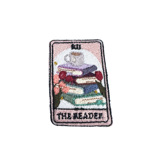 Handmade tarot-inspired "The Reader" embroidered patch featuring books, a teacup, and floral details.
