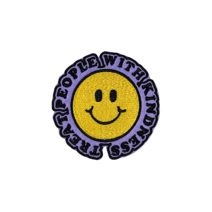 "Round embroidered patch featuring a yellow smiley face with the phrase 'Treat People with Kindness' in black text on a soft lavender background."
