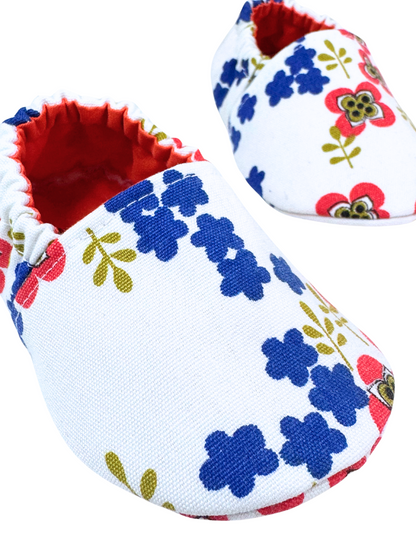 “Close-up of bold floral pattern on handmade baby shoes, upcycled fabric, 3-6 months”

