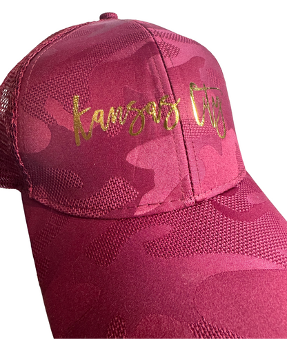 Wine camouflage cap with gold text on a white background