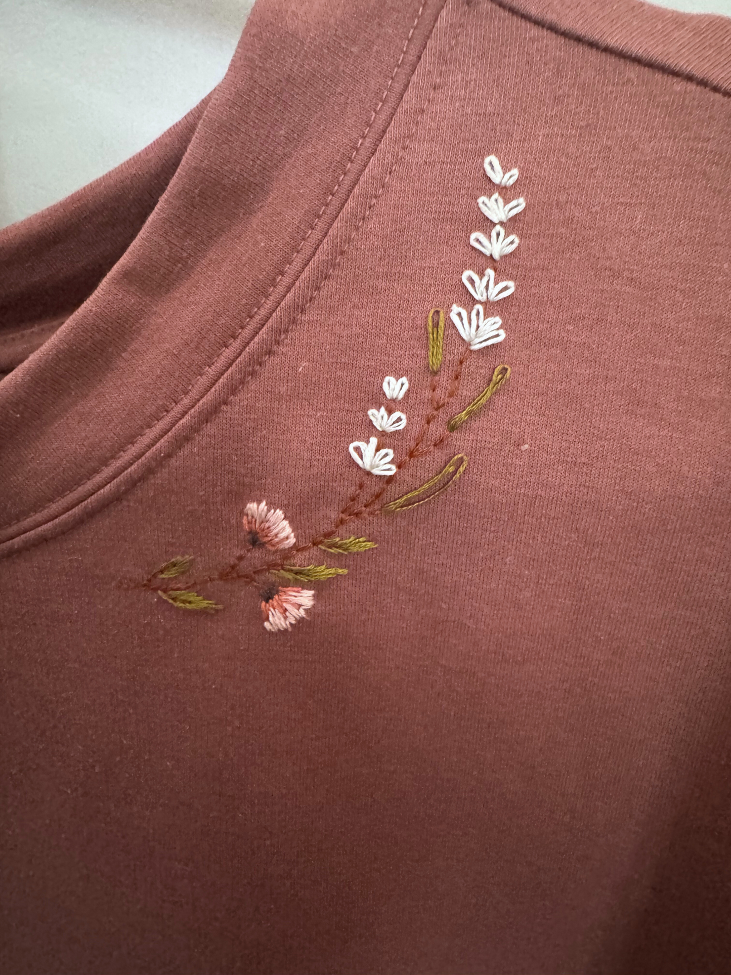 Embroidered floral design on a pink sweatshirt