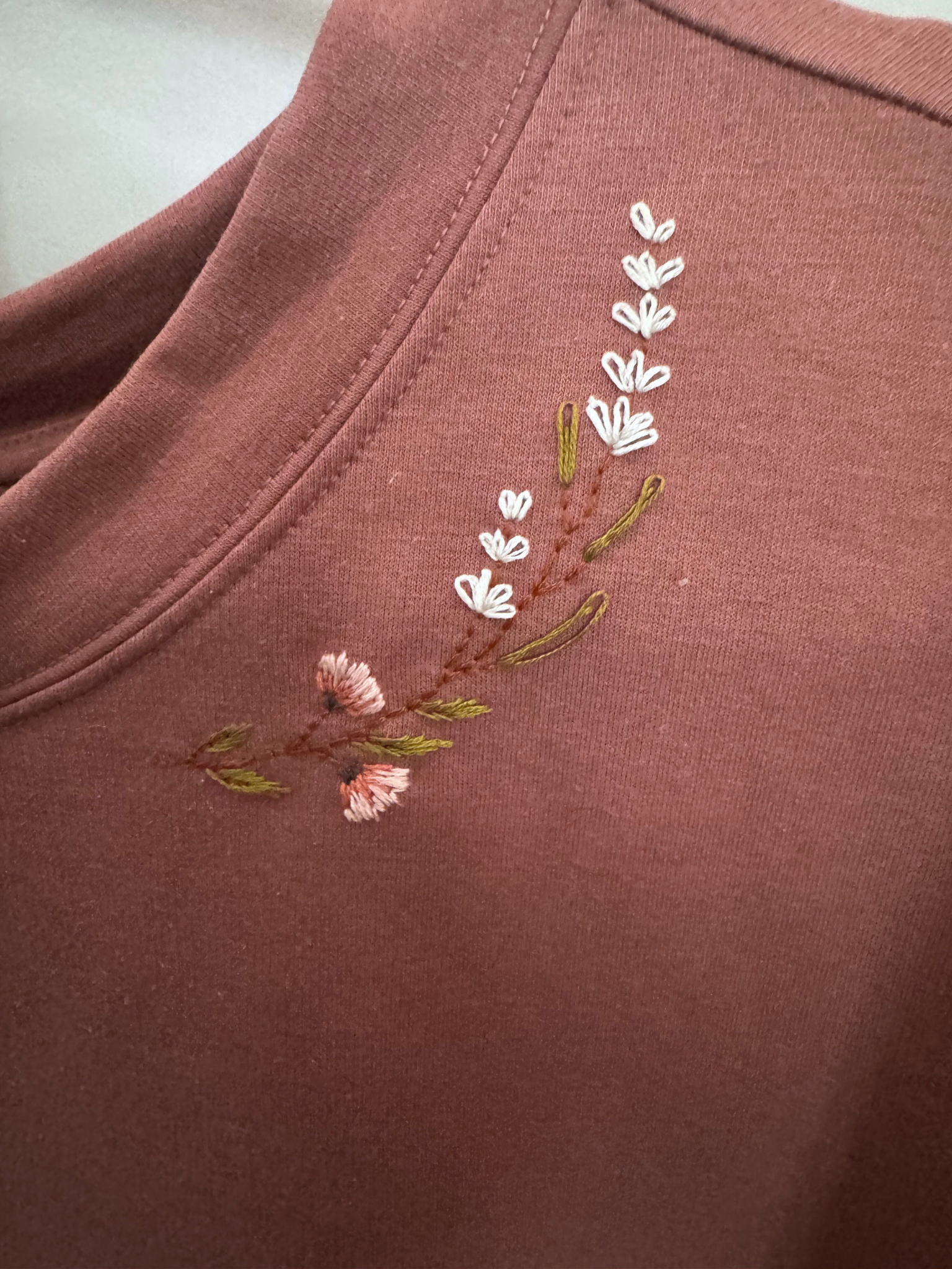 Embroidered floral design on a pink sweatshirt