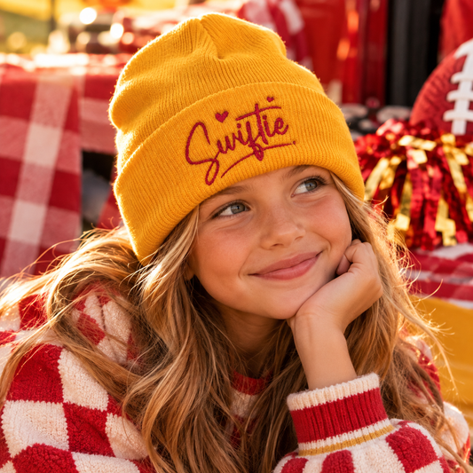 Youth golden Swiftie embroidered beanie styled in a warm Kansas City gameday lifestyle scene.