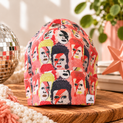 Ziggy Stardust-inspired baby beanie with colorful portrait print and folded cuff, styled hero photo